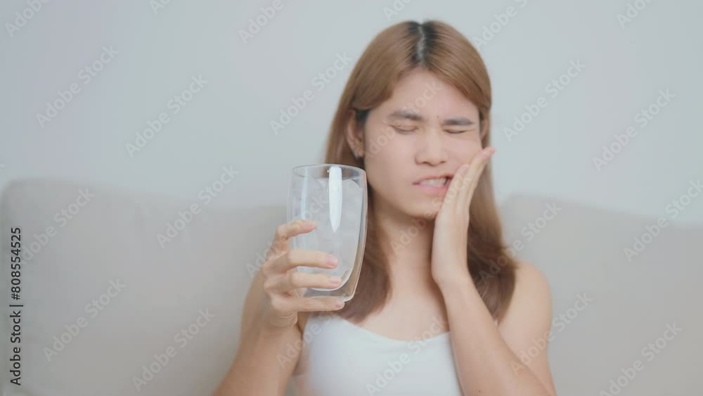 Teeth Sensitive to Cold concept. woman hold Ice Water glass and having toothache and pain after eat. Tooth Decay or Gum Disease, Grinding Teeth and Stress, Exposed Nerve Roots, Crack and Receding Gums Teeth Sensitive to Cold concept. woman hold Ice Water glass and having toothache and pain after eat. Tooth Decay or Gum Disease, Grinding Teeth and Stress, Exposed Nerve Roots, Crack and Receding Gums