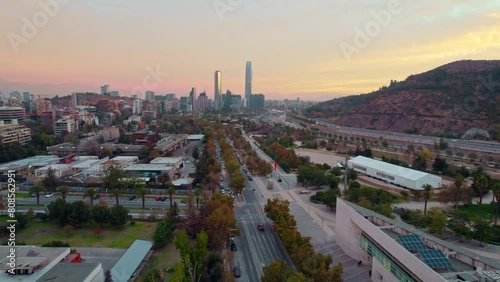 Drone dolly in estrablishing shot of the skyline of Santiago Chile with an orange sunset at the Bicentennial Park of Vitacura photo
