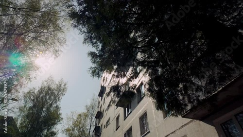 High contrast exterior of aged ex USSR apartment block with sun and lens flare photo