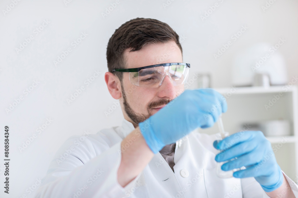 Scientist male with lab glasses working in a laboratory Scientist male with lab glasses working in a laboratory