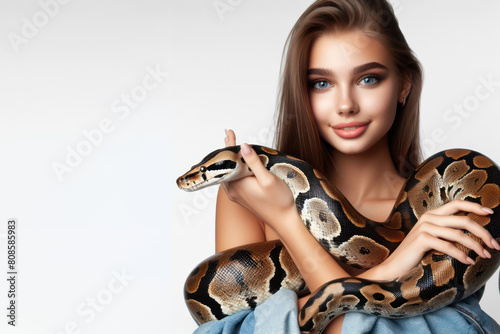 Girl with a large snake boa constrictor in her arms on a white background photo