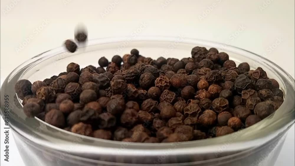 Black pepper drops in a glass bowl on white background, a glass bowl full of black peppers in the center, rotating, micro shot, herbs and spices Black pepper drops in a glass bowl on white background, a glass bowl full of black peppers in the center, rotating, micro shot, herbs and spices