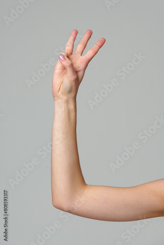 Female hand gesturing numbers on gray background