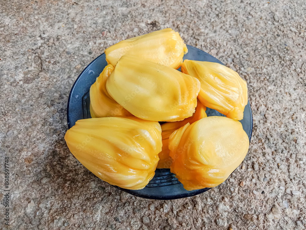 Jackfruit pulp in a blue plate. Riped jackfruit peeled. Sweet yellow ...