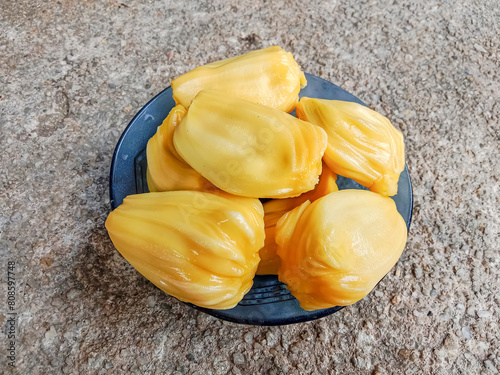 Jackfruit pulp in a blue plate. Riped jackfruit peeled. Sweet yellow jackfruit ripe. Jackfruit (Artocarpus heterophyllus). photo