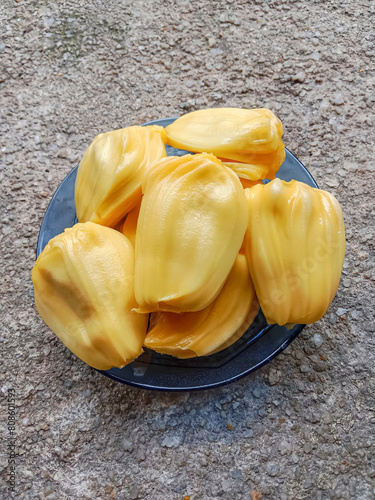 Jackfruit pulp in a blue plate. Riped jackfruit peeled. Sweet yellow jackfruit ripe. Jackfruit (Artocarpus heterophyllus). photo