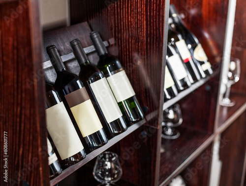 Bottles of wine displayed on the wine shelves in the restaurant or cafe close-up.