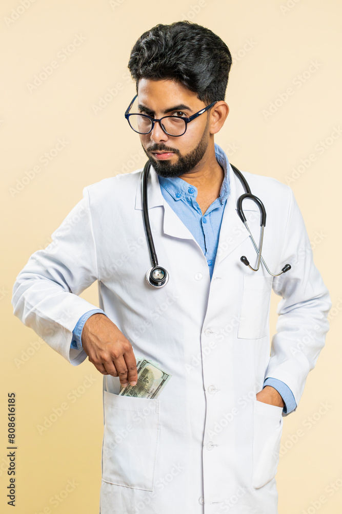 Φωτογραφία Indian speaker doctor cardiologist man receiving bribe from patient, taking money from client, hiding cash into pocket