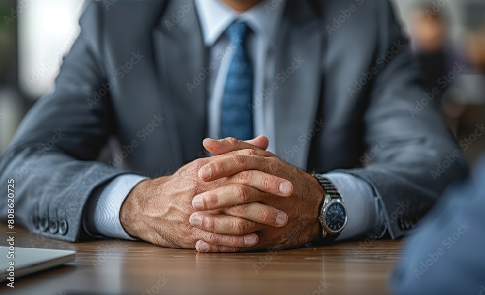 Clasped hands of businessman in formal suit sitting at work or meeting table. Attentive professional taking part in interview, negotiation, ready for dialogue, conversation. Clasped hands of businessman in formal suit sitting at work or meeting table. Attentive professional taking part in interview, negotiation, ready for dialogue, conversation.