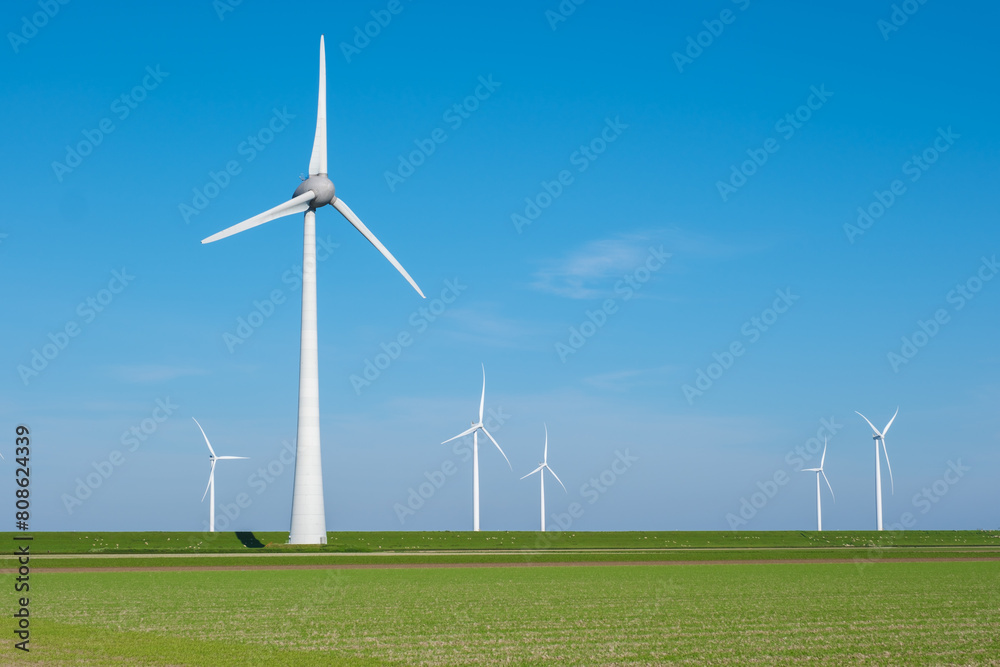 In the picturesque landscape of Flevoland, wind turbines gracefully spin in the green field, harnessing renewable energy with each gentle breeze In the picturesque landscape of Flevoland, wind turbines gracefully spin in the green field, harnessing renewable energy with each gentle breeze