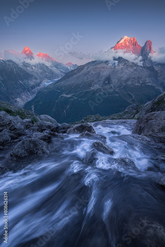 Alpenglow on Drus Peaks and Glaciers, with Mountain Stream at Sunset photo