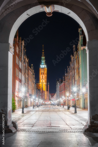 Dluga Street's Illuminated Arch Framing Gdańsk's Iconic Church Spire photo