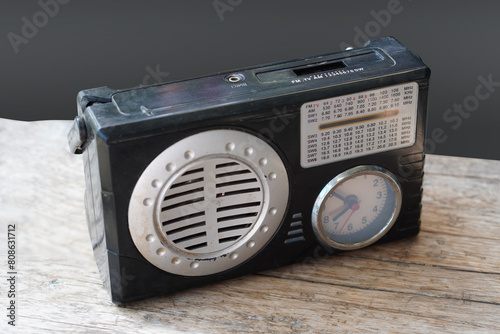 top view old and dirty black radio and clock on wooden floor, grey background, technology, object, music, fashion, copy space