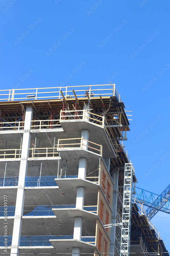 Crane near a construction site with a building under construction Crane near a construction site with a building under construction