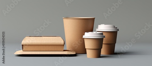 Eco friendly disposable coffee nug and tableware set including a gray background with a cardboard cup for takeout coffee or delivery service featuring a copy space image for text photo