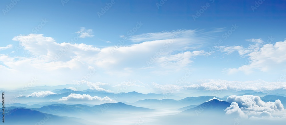 The panoramic view showcases a serene sky adorned with light blue hues and adorned with beautifully smooth clouds leaving ample room for a copy space image