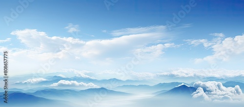 The panoramic view showcases a serene sky adorned with light blue hues and adorned with beautifully smooth clouds leaving ample room for a copy space image