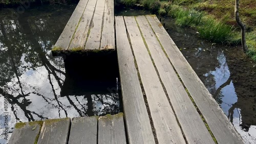 Wooden bridge over the pond at Tenjuan Buddhist Temple, Kyoto Japan. photo