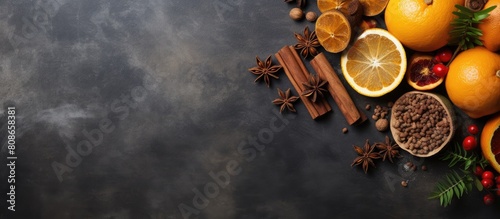 Copy space image of a festive cooking background featuring a variety of nuts juicy oranges aromatic anise stars and fragrant cinnamon beautifully arranged on a rustic stone background with decorative