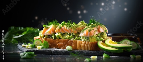 On a grey table there is a copy space image of open sandwiches topped with spinach and avocado salmon