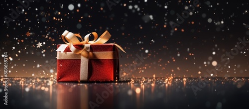 A festive holiday photo with a beautifully wrapped Christmas present surrounded by copy space © Ilgun