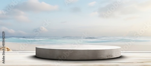 Front view of a grungy grey concrete stone platform podium for cosmetics or products set against a white beach sand background with copy space image