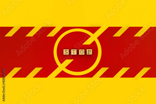 赤いラインにSTOPのアルファベットを並べた黄色い禁止マークの看板 photo
