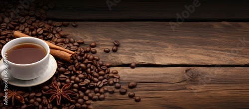 A horizontal photo with a wooden background featuring a coffee background with coffee beans and cinnamon sticks Copy space image