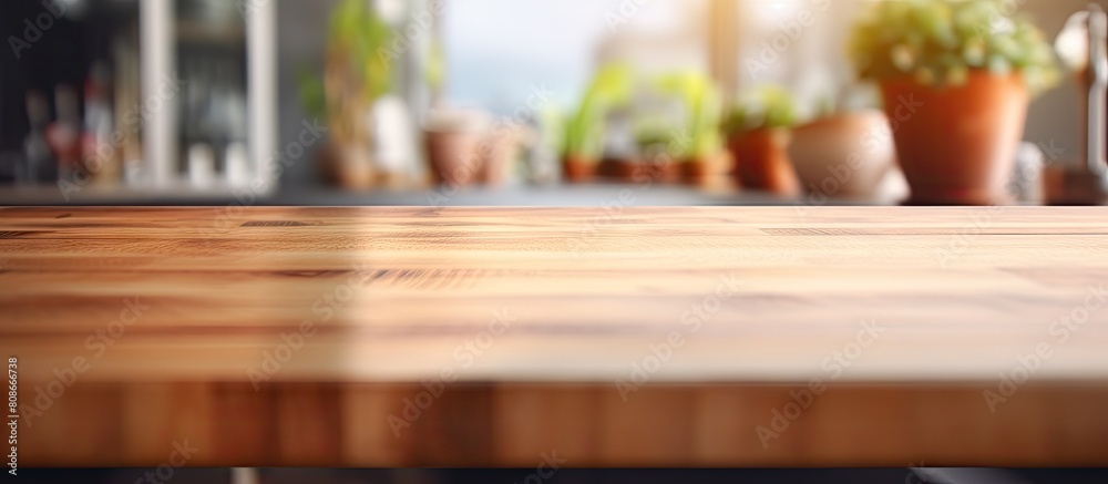 A wooden table top is shown against a blurred kitchen room background in this copy space image perfect for showcasing products or designing key visual layouts A wooden table top is shown against a blurred kitchen room background in this copy space image perfect for showcasing products or designing key visual layouts