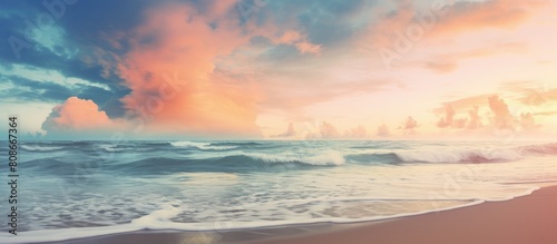 A vintage style color filtered copy space image of a tropical beach where soft sand meets the sea and a picturesque sunset sky with clouds create an abstract background This evokes a sense of freedom