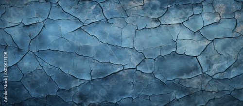 An abstract background for design featuring an aged blue textured wall with crack lines and patches of black dirt Perfect for copy space image