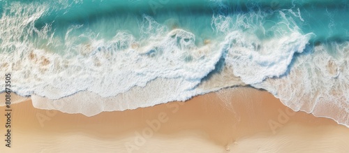 Aerial shot of a sandy beach with rippling waves perfect for a summer themed copy space image