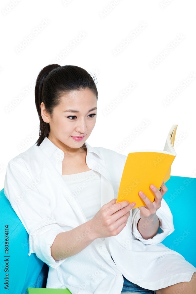 Shed young woman sitting on the sofa reading a book Shed young woman sitting on the sofa reading a book