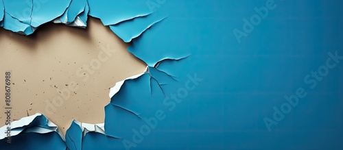 A torn piece of cardboard is seen placed on a blue background The ripped paper exhibits a torn edge making it a distinctive design element. Copy space image. Place for adding text and design