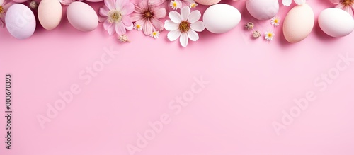 A pastel pink background with a flat lay style features colorful naturally dyed Easter eggs and spring flowers The image includes copy space for text
