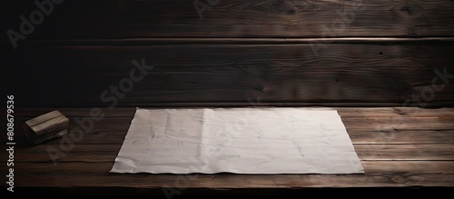An old wooden table with a white sheet of paper providing ample copy space for writing or drawing