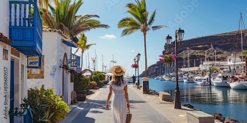 A lady strolling in the harbor of the seaside village in the southern part of Gran Canaria, Spain. photo