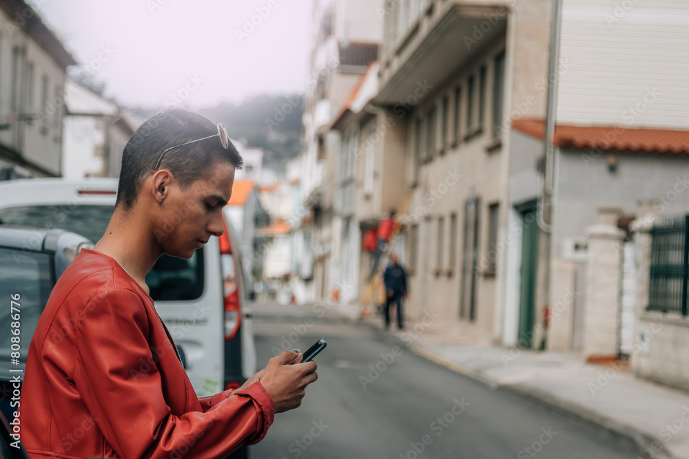 urban young man playing with phone on the street urban young man playing with phone on the street