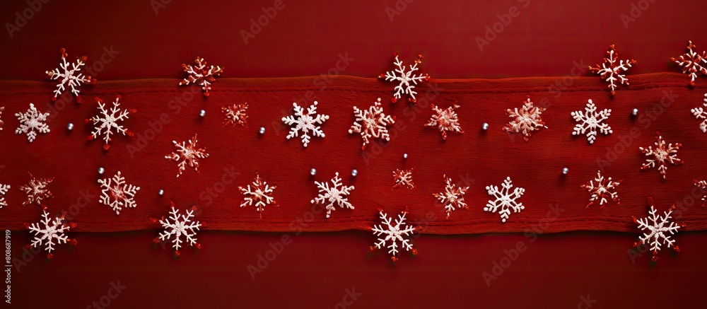 A top down view of Christmas snowflakes on a red knitted background with ample space for additional imagery A top down view of Christmas snowflakes on a red knitted background with ample space for additional imagery