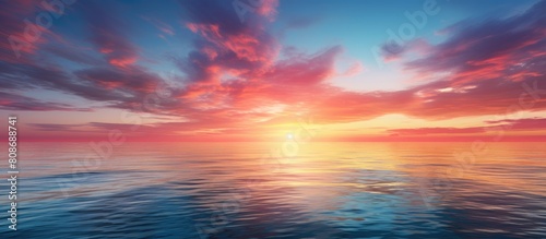 A stunning idyllic landscape featuring a colorful sunset or sunrise over the sea with a clear sky reflecting light on the water s surface This breathtaking image showcases the beauty of nature while © Ilgun