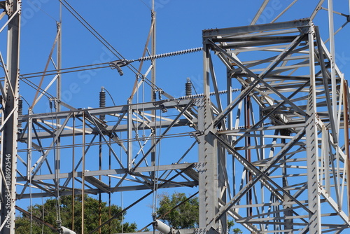 Power lines against a clear blue sky with distant trees