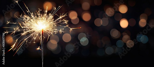 A festive sparkler adds an enchanting touch to a Christmas and New Year party with its vibrant display against a captivating black background creating a mesmerizing copy space image