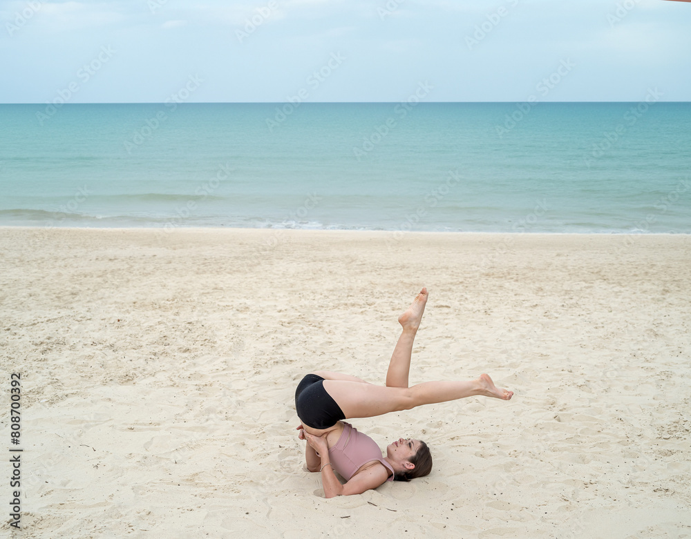 Young caucasian female trainer practicing yoga at sea beach. Sport for weight loss exercise Young caucasian female trainer practicing yoga at sea beach. Sport for weight loss exercise