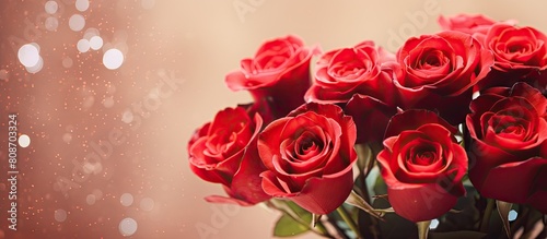 Valentine s Day themed photo of a bouquet of red roses with a shiny bokeh background providing space for text. Copy space image. Place for adding text and design