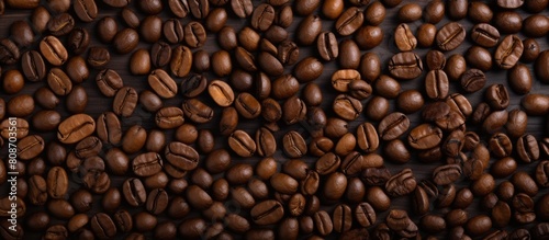 Top view of a background consisting of dark roast coffee beans with copy space image