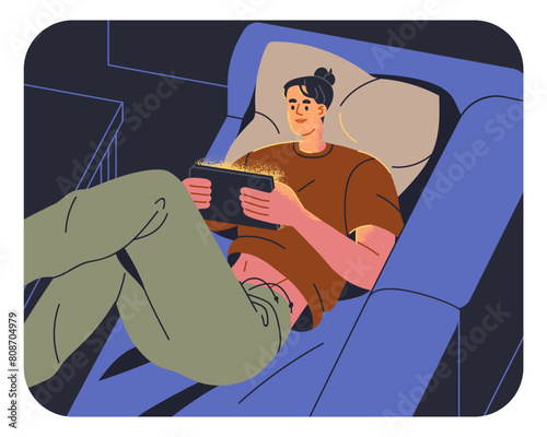 Woman using digital device, watching screen late at night. Girl lying on couc...