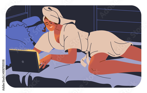 Woman lying on bed with laptop computer, surfing internet at night. Happy you...