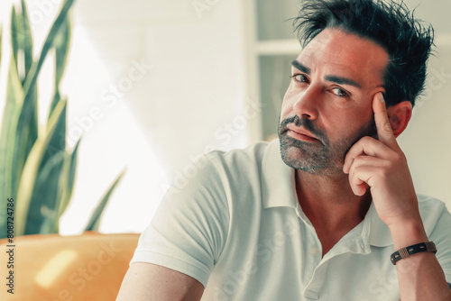 attractive man at home looking thoughtful or deciding