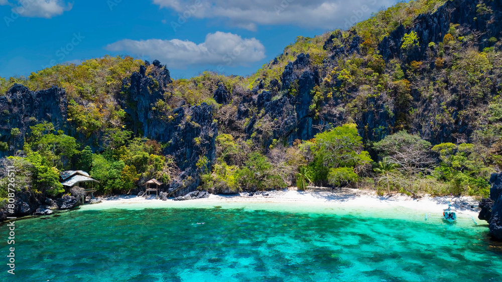The  white sand beach bathed by a crystal clear water. Entalula island, Bacuit Bay, El Nido, Palawan, Philippines.