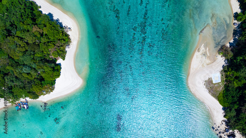 The aerial view of white sand beach tropical with seashore as the island in a coral reef ,blue and turquoise sea Amazing nature landscape with blue lagoon photo